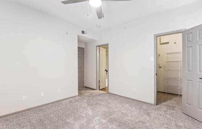 A room with a ceiling fan and two doors.