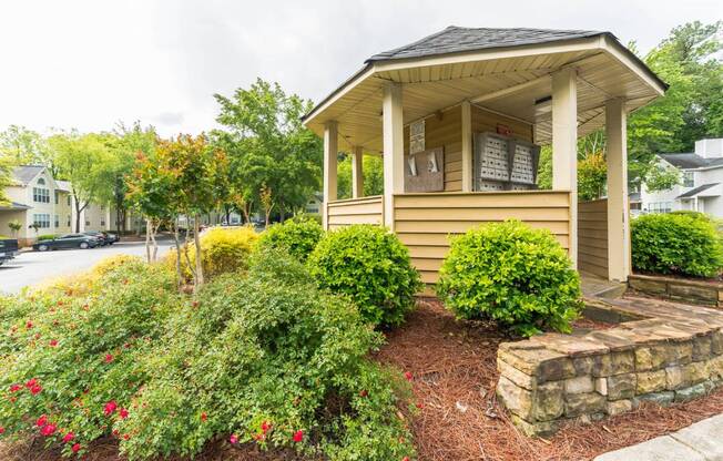 A small house with a porch surrounded by a garden.