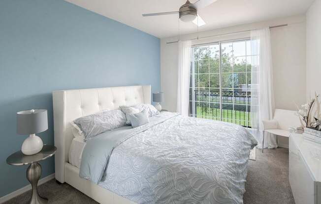 a blue and white bedroom with a bed and a window