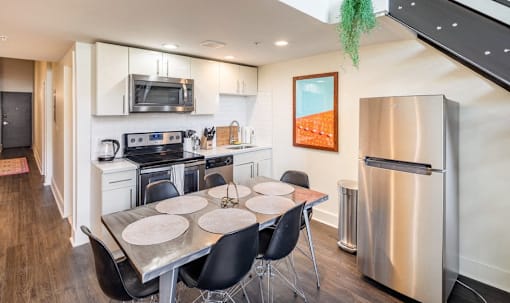 a kitchen with stainless steel appliances and a table with chairs