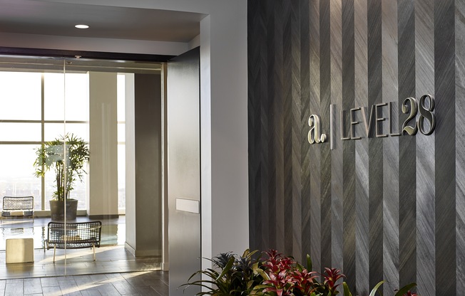 A modern lobby with a plant and a sign that says