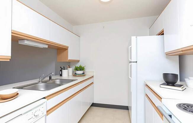 A small, clean kitchen with white cabinets and appliances.