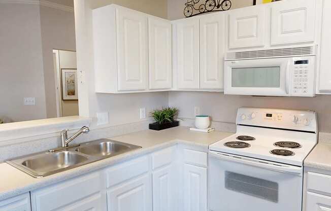 a kitchen with white Shaker cabinets and white appliances