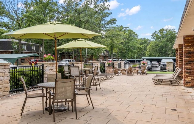 a patio with tables chairs and umbrellas