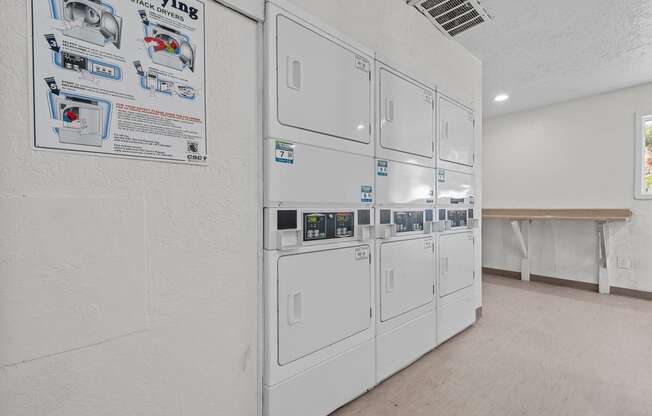 a white kitchen with a row of white refrigerators in it