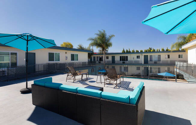 a pool with chairs and umbrellas next to a building