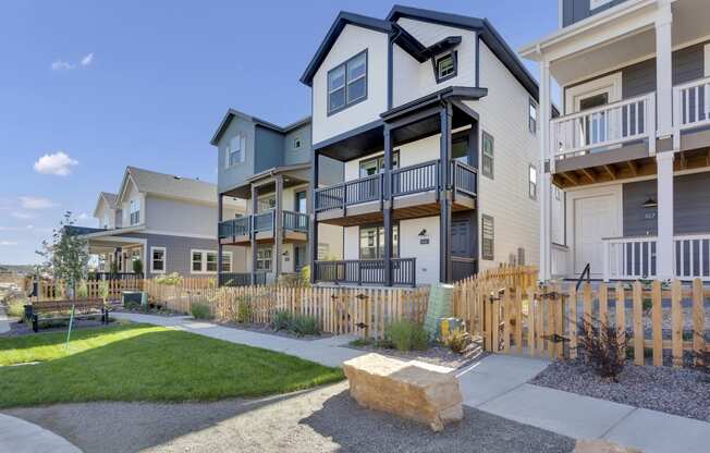 an exterior view of an apartment building with a sidewalk and grass