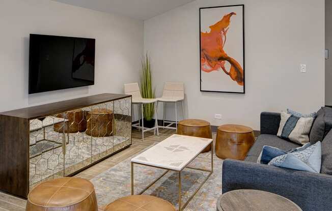 a living room with couches and stools and a television