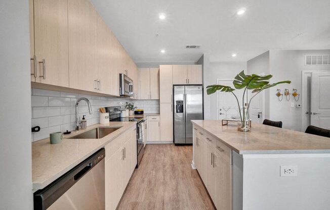 a kitchen with white cabinets and a stainless steel refrigerator