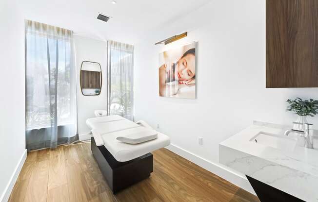 a spa room with a massage table and sink