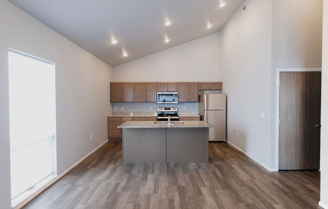 a kitchen with stainless steel appliances and wooden floors