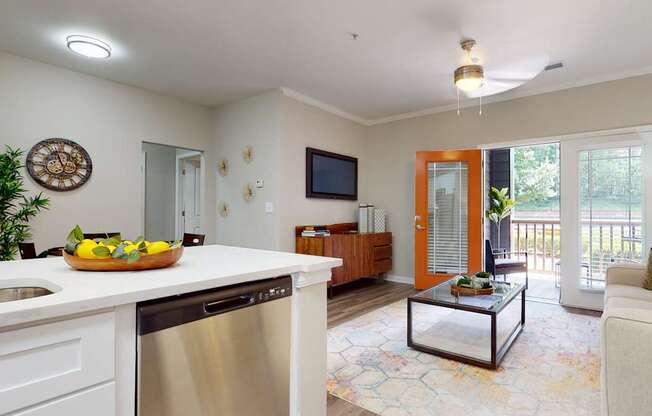 A modern kitchen with a stainless steel dishwasher and a glass coffee table.