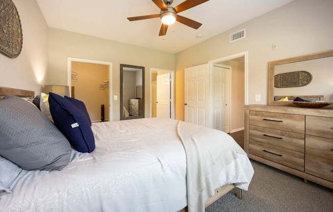 A bedroom with a bed, dresser, and mirror.