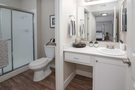 Model apartment bathroom with a shower toilet and sink and a mirror