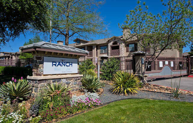A ranch-style home with a stone sign in front.