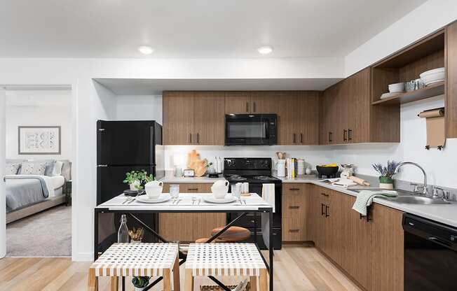 a kitchen in a 555 waverly unit with a table and two stools in the at QUINN BY VINTAGE, Shoreline