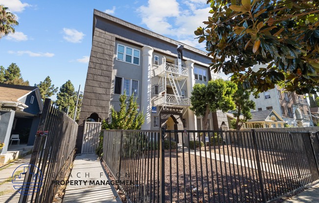 an apartment building with a gate and a fence in front of it