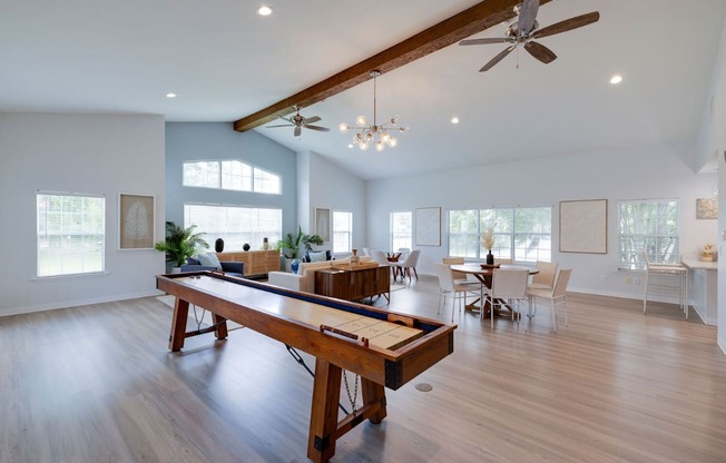 A spacious room with a long wooden table and chairs.