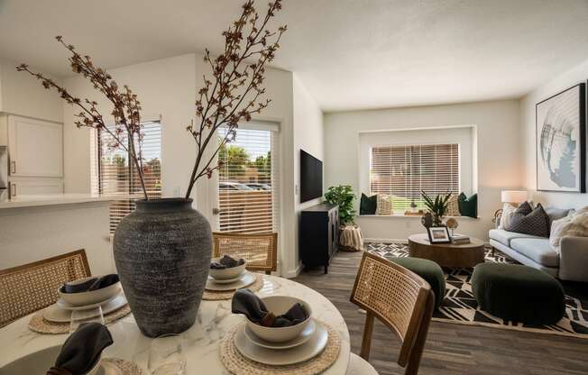 an open living room and dining room with a large vase on the table