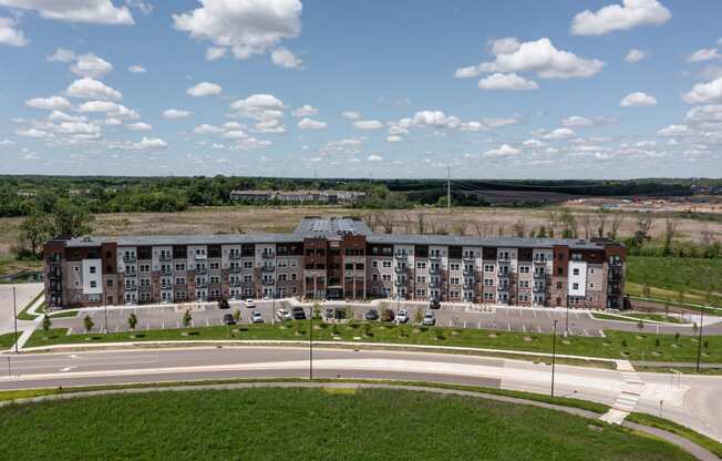 an aerial view of an apartment building overlooking a road and a field