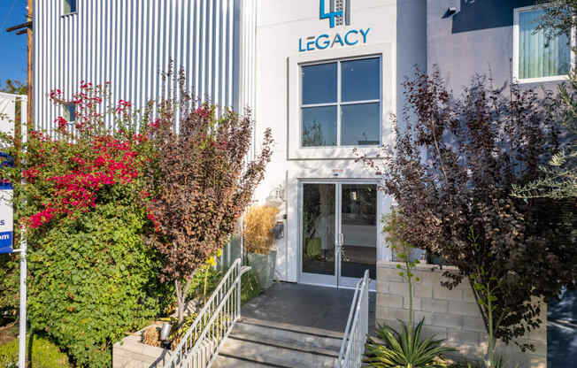 the facade of legacy office building with stairs and plants