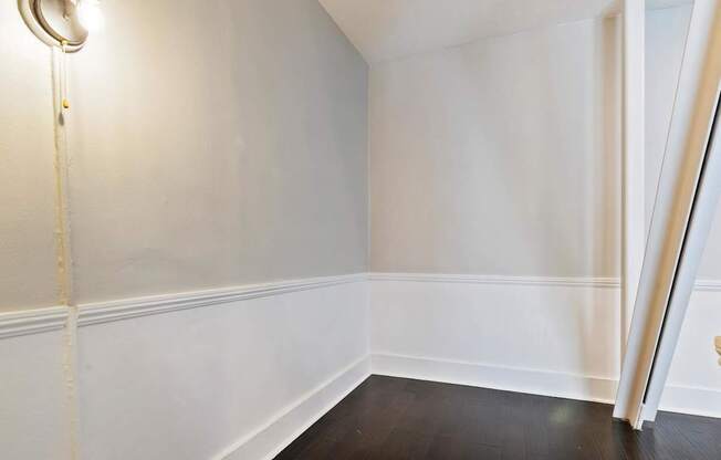 A white wall with a lamp on the left side in a studio apartment in Pasadena, CA at Brookmore.