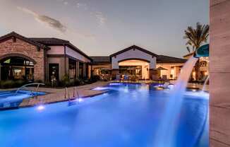 a swimming pool with blue lights in front of a resort