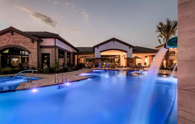 a swimming pool with blue lights in front of a resort