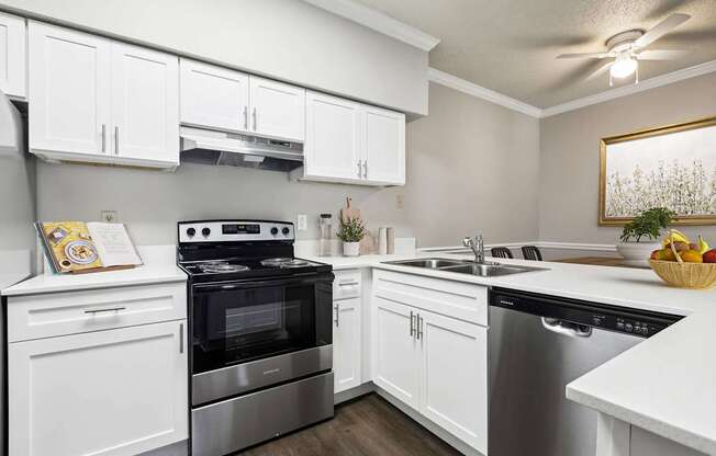 A modern kitchen with white cabinets and stainless steel appliances.