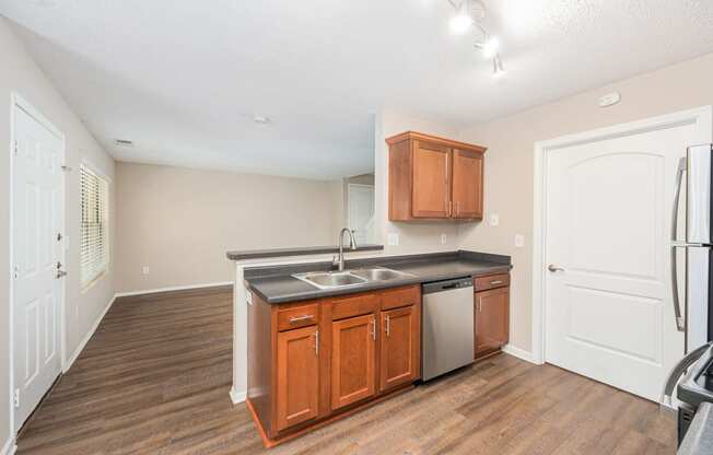 a kitchen with wooden cabinets and a stainless steel sink and a refrigerator