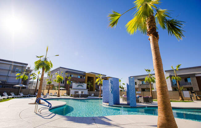 a swimming pool with palm trees and buildings in the background