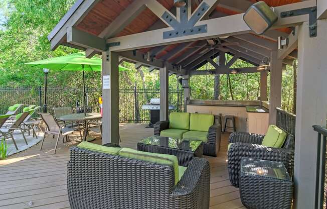 a covered patio with wicker furniture and a grill at Lagniappe of Biloxi Apartment Homes, Biloxi, MS, Mississippi