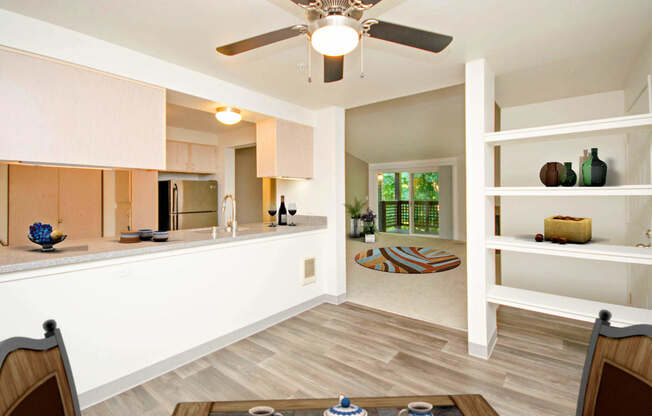 a kitchen and living room with a ceiling fan