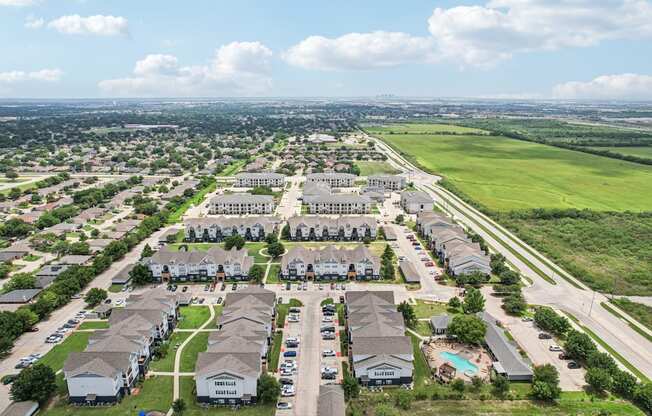 A bird's eye view of a residential area with multiple houses and a swimming pool.