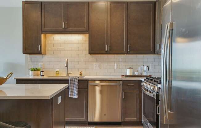 a kitchen with wood cabinets and stainless steel appliances