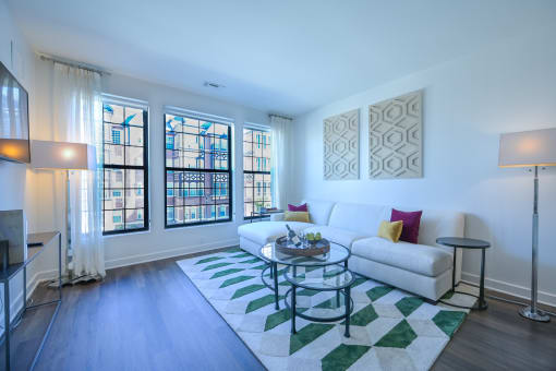 a living room with a white couch and a glass coffee table