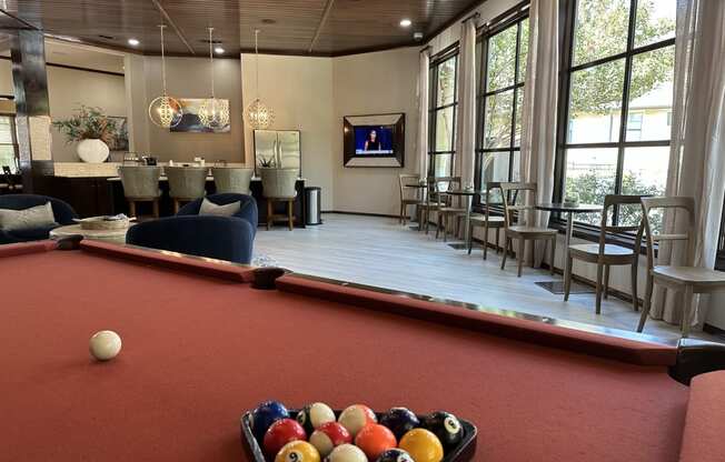 a pool table and bar in the clubhouse at the preserve at great pond apartments in windsor