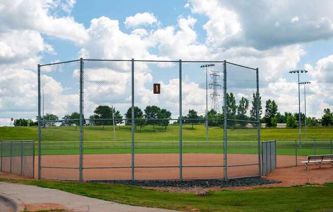 A baseball field is enclosed by a chain link fence.