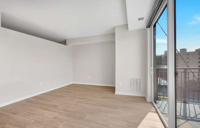 a bedroom with a large window and hardwood floors