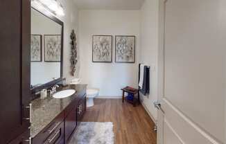 a bathroom with a sink mirror and toilet in a 555 waverly unit