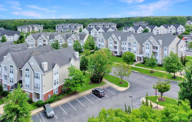 an aerial view of an apartment complex with a car parked in a parking lot
