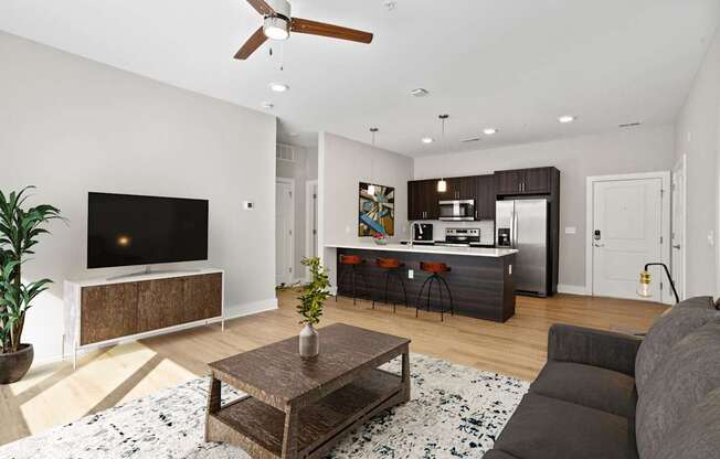 A living room with a flat screen TV and a wooden coffee table.