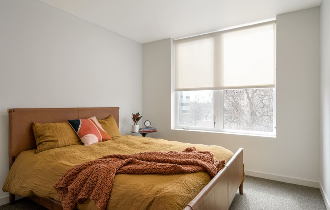 a bedroom with a bed and a large window at The Lucy Boise Apartments, Boise, 83702