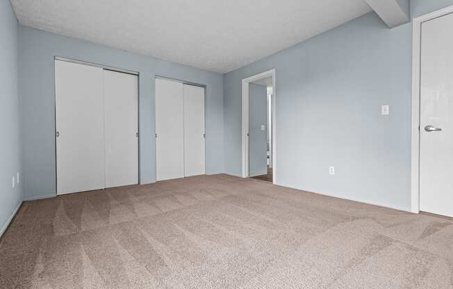 the living room of an apartment with carpet and blue walls