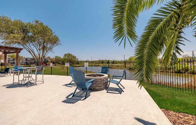 A concrete patio with blue chairs and a table.