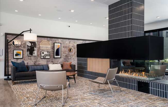 Lobby with a sofa and chairs and gas fireplace next to artwork
