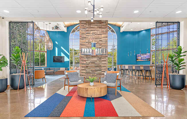 a lobby with a round table and chairs and a blue wall with a large window