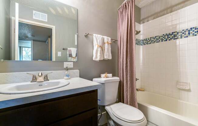 A bathroom with a white sink and a white toilet.