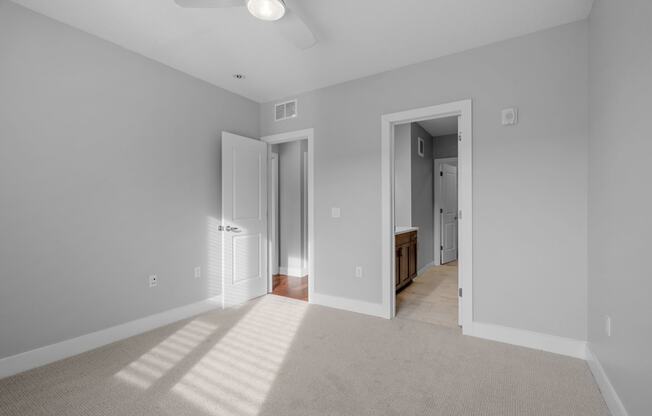 a spacious living room with gray walls and a carpeted floor