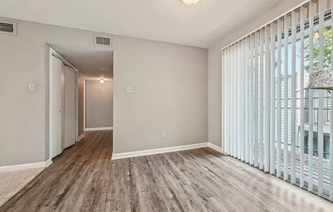 Bright and inviting apartment with sleek hardwood floors and large sliding glass doors leading to a private balcony.